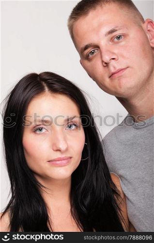 Beautiful pensive man and woman stand near gray wal