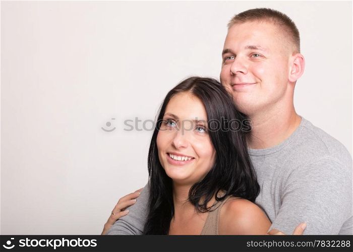 Beautiful pensive man and woman standing near gray wal