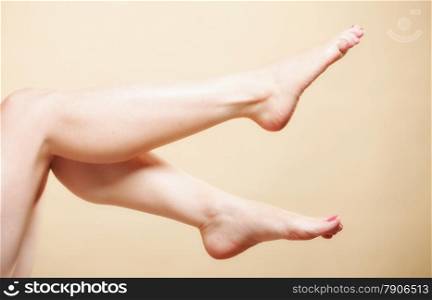 Beautiful perfect long naked woman girl legs barefoot body care pedicure on orange