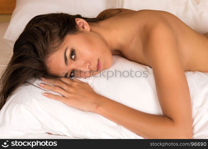 Beautiful petite Eurasian woman nude in bed