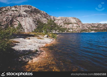 Beautiful Photo Norway, Scandinavia. Beautiful landscape on the lake shore middle of the stone mountains. 