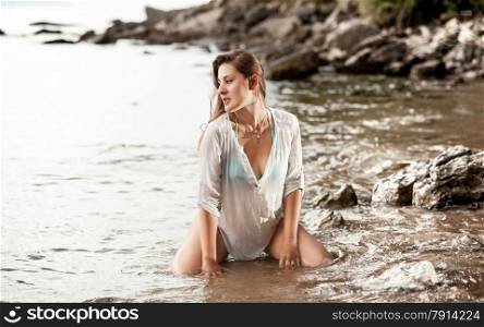 Beautiful photo of sexy stylish woman sitting in water at sea shore