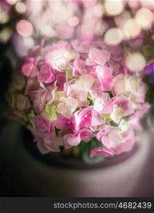 Beautiful pink green hydrangea flowers in pot on cozy bokeh lighting, soft