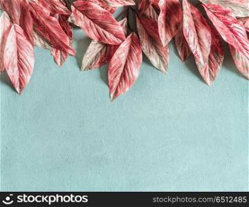 Beautiful pink leaves border on pastel blue background , top view, flat lay. Nature concept