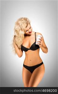 Beautiful pinup bikini model with take away coffee on grey background.