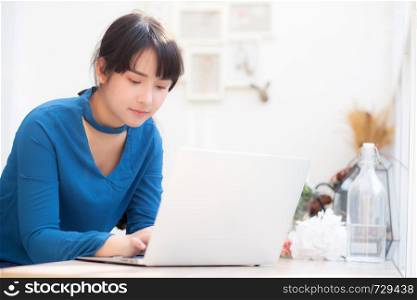Beautiful portrait asia young woman working online on laptop sitting at cafe shop, professional female freelance using notebook computer, business and communication concept.