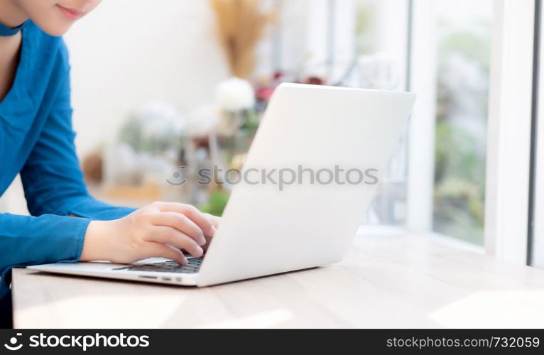 Beautiful portrait asia young woman working online on laptop sitting at cafe shop, professional female freelance using notebook computer, business and communication concept.