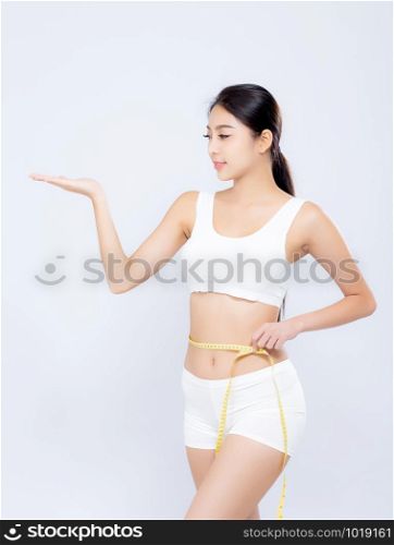 Beautiful portrait asian woman diet and slim with measuring waist for weight presenting something on hand isolated on white background, girl have cellulite loss tape measure, health and wellness concept.