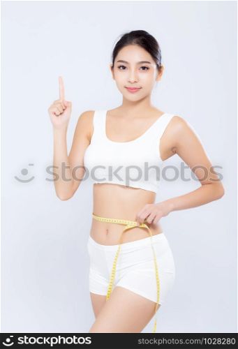 Beautiful portrait asian woman diet and slim with measuring waist for weight finger pointing something isolated on white background, girl have cellulite loss with tape measure, health and wellness concept.