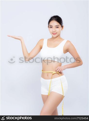 Beautiful portrait asian woman diet and slim with measuring waist for weight presenting something on hand isolated on white background, girl have cellulite loss tape measure, health and wellness concept.