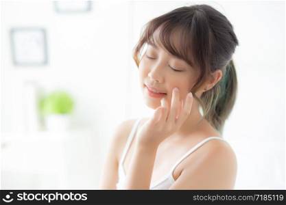 Beautiful portrait asian woman makeup of cosmetic, girl hand touch cheek and smile attractive, face beauty perfect with wellness in the bedroom with skin care and healthcare concept.