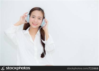 Beautiful portrait asian young woman happy enjoy and fun listen music with headphone sitting in living room, lifestyle of girl relax sound radio with earphone, leisure and technology concept.