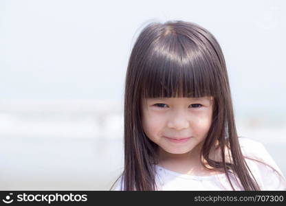 Beautiful portrait little girl asian of a smiling standing at beach, kid leisure and joyful in outdoor.