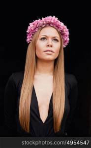 Beautiful portrait of a blonde girl with a pink crown of flowers on her head