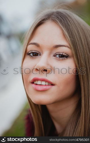 Beautiful portrait of a blonde girl with grass of background