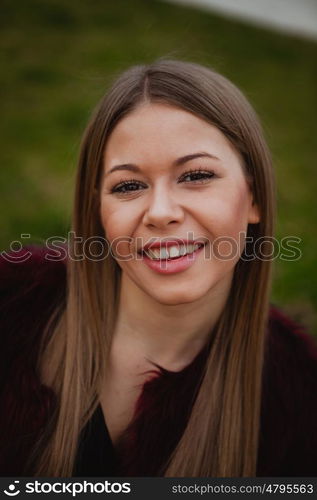 Beautiful portrait of a blonde girl with grass of background