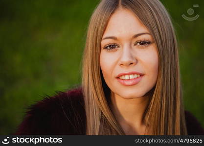 Beautiful portrait of a blonde girl with grass of background