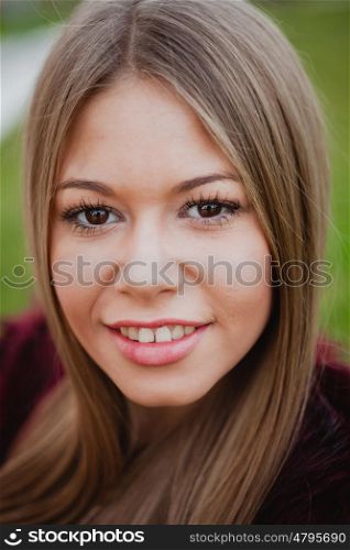 Beautiful portrait of a blonde girl with grass of background