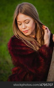 Beautiful portrait of a blonde girl with grass of background