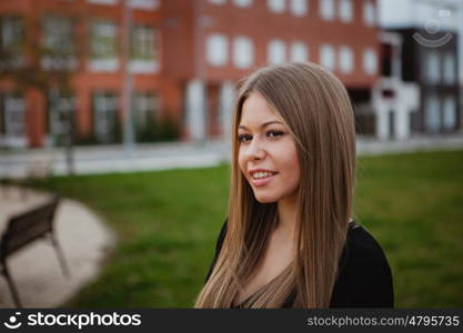 Beautiful portrait of a blonde girl with grass of background