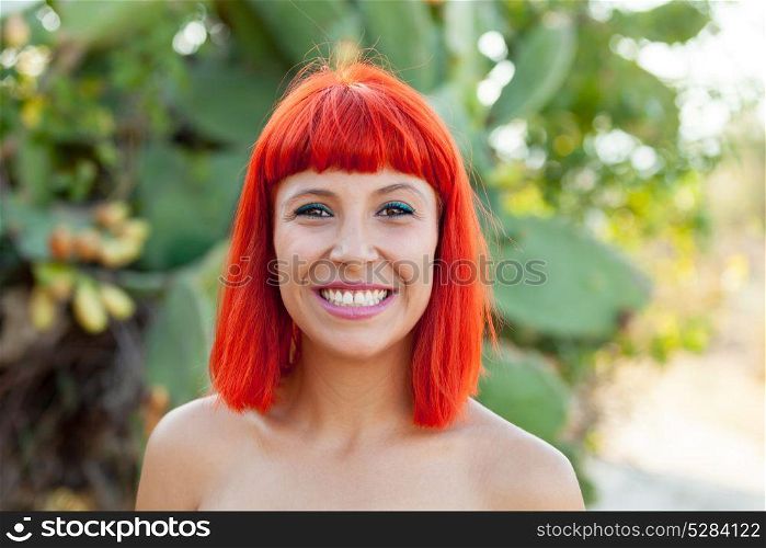 Beautiful portrait of a red hair girl in a park with cute shoulders