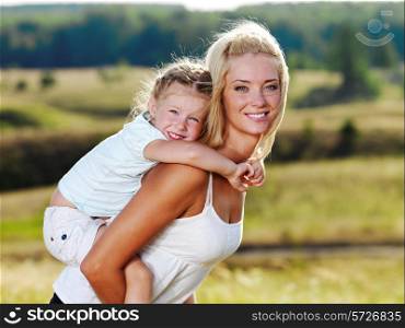 Beautiful Portrait of mother and little pretty girl outdoors