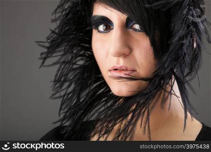 Beautiful Portrait of woman. Studio shot. Professional make up and hair style black feather
