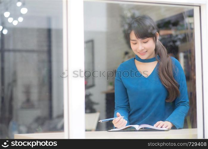 Beautiful portrait young asia woman writer writing on notebook or diary with happy, lifestyle of asian girl is student, female planning working, education and business concept.