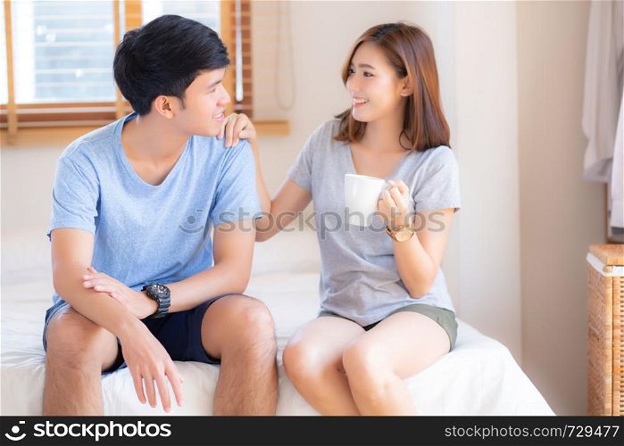 Beautiful portrait young asian couple give a cup of coffee with smiling and happy together, family take care with health, man give water woman in the bedroom, lifestyle concept.