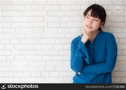 Beautiful portrait young asian woman confident thinking with cement and concrete background, girl standing expression serious or doubts with idea, lifestyle concept.