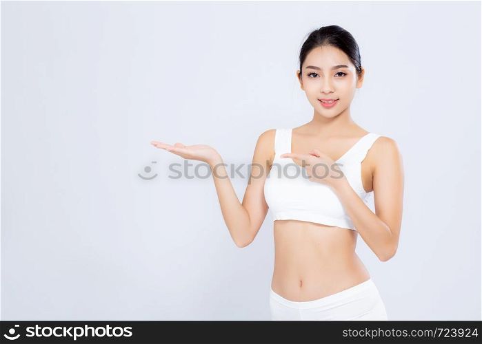 Beautiful portrait young asian woman fit smiling gesture showing presenting something empty on hand isolated on white background, healthy and diet concept.
