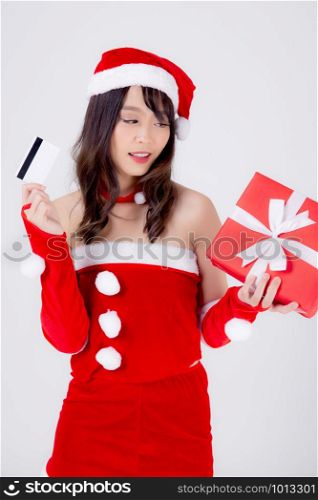 Beautiful portrait young asian woman happy holding credit card and red gift box in Christmas holiday isolated on white background, beauty asia girl surprise shopping with credit card in xmas day.