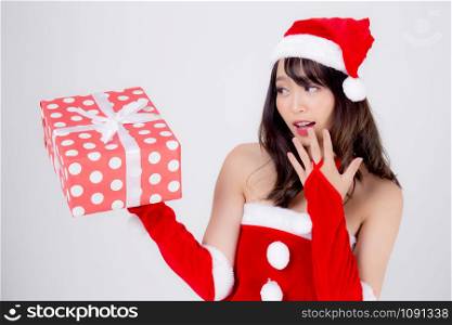 Beautiful portrait young asian woman happy holding red gift box with excited in xmas holiday isolated on white background, asia girl surprise and celebrating in festive Christmas and new year.