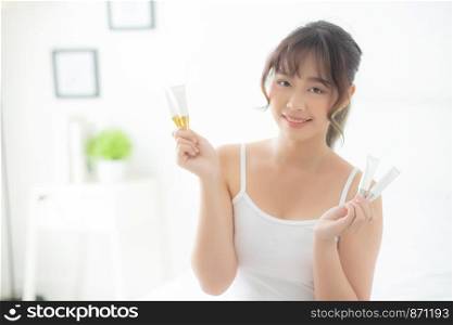 Beautiful portrait young asian woman holding and presenting cream or lotion product, beauty asia girl show cosmetic makeup and moisturizing for skin care, healthy care and wellness concept.
