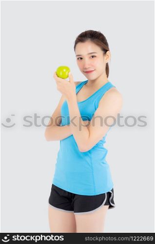 Beautiful portrait young asian woman in sport clothing with satisfied and holding green apple isolated on white background, girl asia have shape and wellness, exercise for fit with health concept.