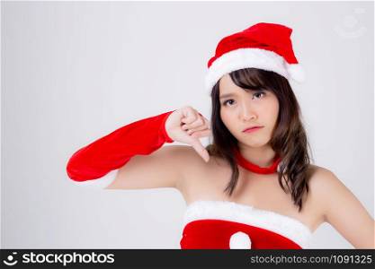 Beautiful portrait young asian woman Santa costume gesture thumbs down sign with unhappy negative in holiday xmas, beauty asia girl expression dislike and upset in Christmas isolated white background.