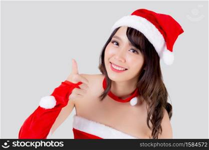 Beautiful portrait young asian woman Santa costume smiling gesture thumbs up sign with happy in holiday xmas, beauty asia girl cheerful celebrating in Christmas isolated on white background.