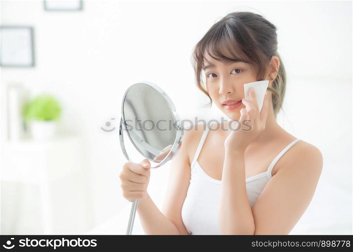 Beautiful portrait young asian woman smile and joy with skin care use oil blotting paper on face looking mirror in the room, beauty asia girl happy and cheer makeup and cosmetic, health care on facial concept.