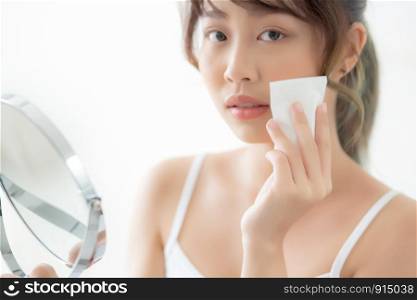 Beautiful portrait young asian woman smile and joy with skin care use oil blotting paper on face looking mirror in the room, beauty asia girl happy and cheer makeup and cosmetic, health care on facial concept.