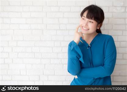 Beautiful portrait young asian woman smiling and confident thinking with cement and concrete background, girl standing expression serious or doubts with idea and inspiration, lifestyle concept.
