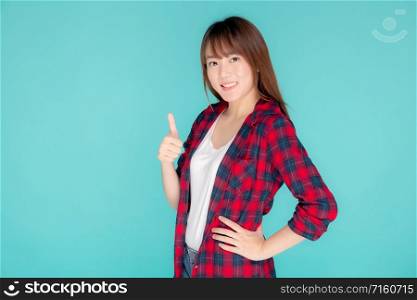 Beautiful portrait young asian woman smiling confident and excited summer holiday isolated blue background, beauty asia model girl gesture thumb up and cheerful with journey, travel concept.