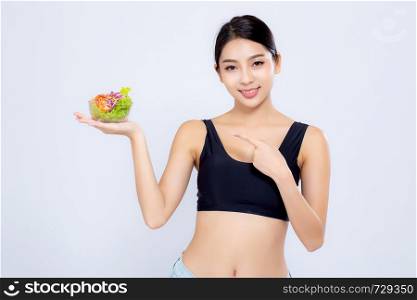 Beautiful portrait young asian woman smiling holding and pointing salad vegetable food isolated on white background, girl diet eating vegetarian for healthy, health care or wellness concept.