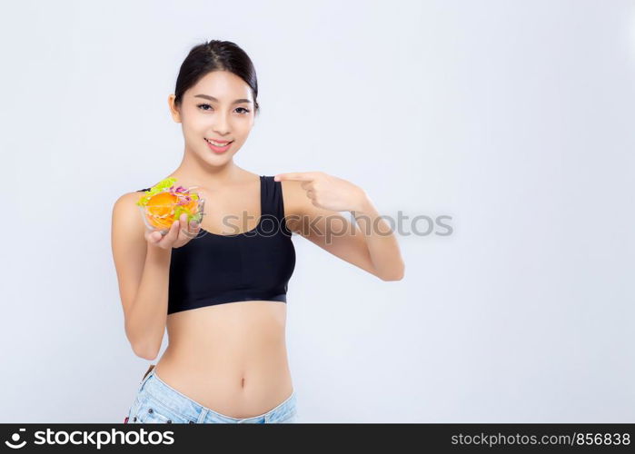 Beautiful portrait young asian woman smiling holding and pointing salad vegetable food isolated on white background, girl diet eating vegetarian for healthy, health care or wellness concept.