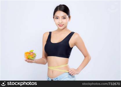 Beautiful portrait young asian woman smiling holding salad vegetable food and measuring waist for weight isolated on white background, girl diet with cellulite loss with tape measure, health care or wellness concept.