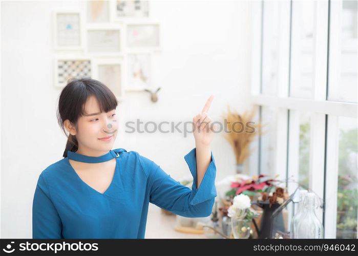 Beautiful portrait young asian woman smiling sitting at cafe pointing something, model girl happy with relax and resting, lifestyle concept.