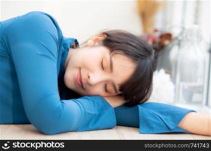 Beautiful portrait young asian woman smiling sleep at cafe, model girl happy with relax and resting, female lying, lifestyle concept.