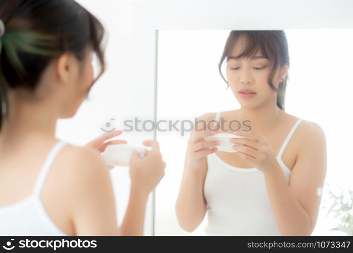 Beautiful portrait young asian woman smiling with skin care cosmetic use oil blotting paper on face looking mirror at room, beauty asia girl wipe and cleansing makeup with tissue, clean on facial concept.
