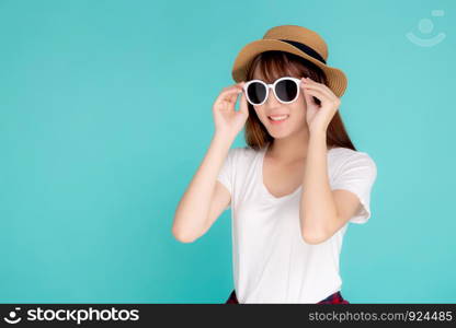 Beautiful portrait young asian woman wear hat and holding sunglasses smiling confident enjoy journey summer trip in vacation isolated on blue background, tourist asia girl cheerful with travel.