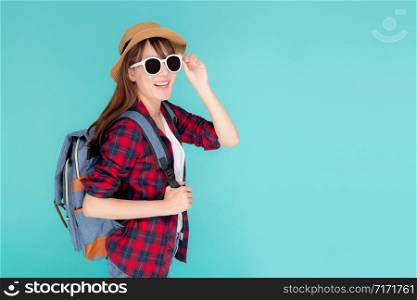 Beautiful portrait young asian woman wear sunglasses and hat smile excited and confident enjoy summer trip holiday isolated blue background, girl cheerful having backpack in vacation, travel concept.