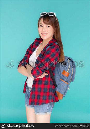 Beautiful portrait young asian woman wear sunglasses on head smile expression confident enjoy summer holiday isolated blue background, model girl fashion having backpack, travel concept.